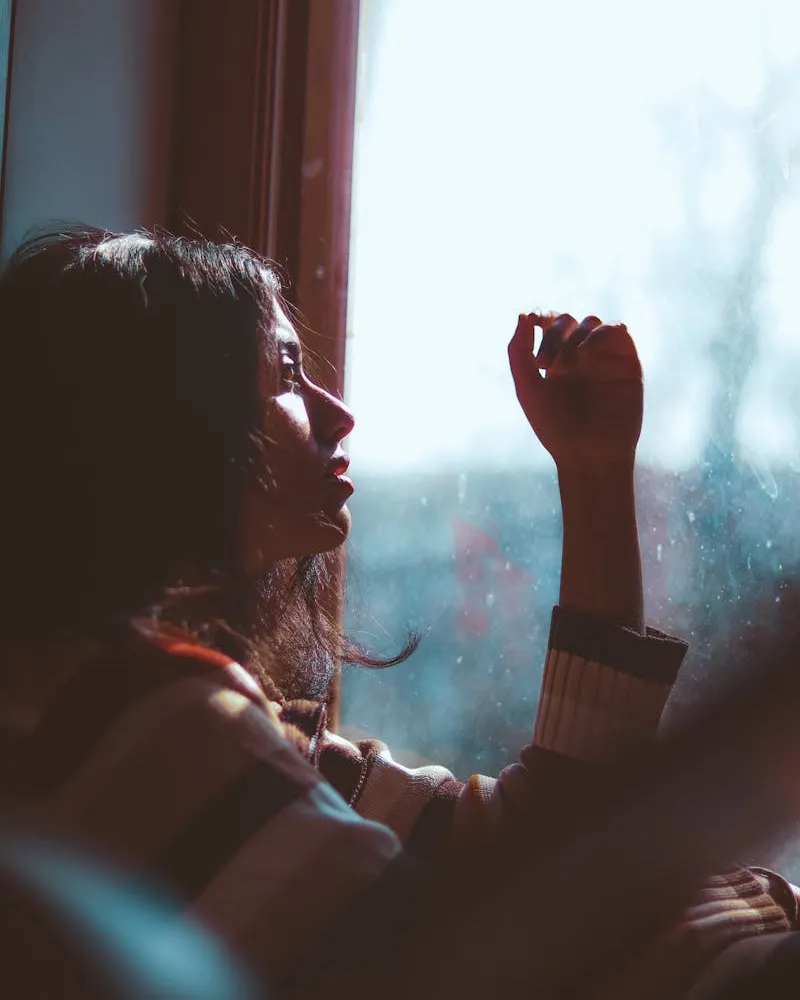 Woman contemplating change by a window